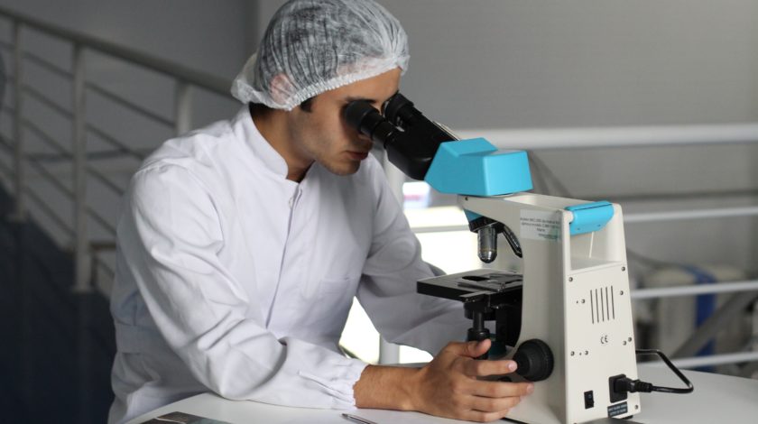 medical professional looking through a microscope